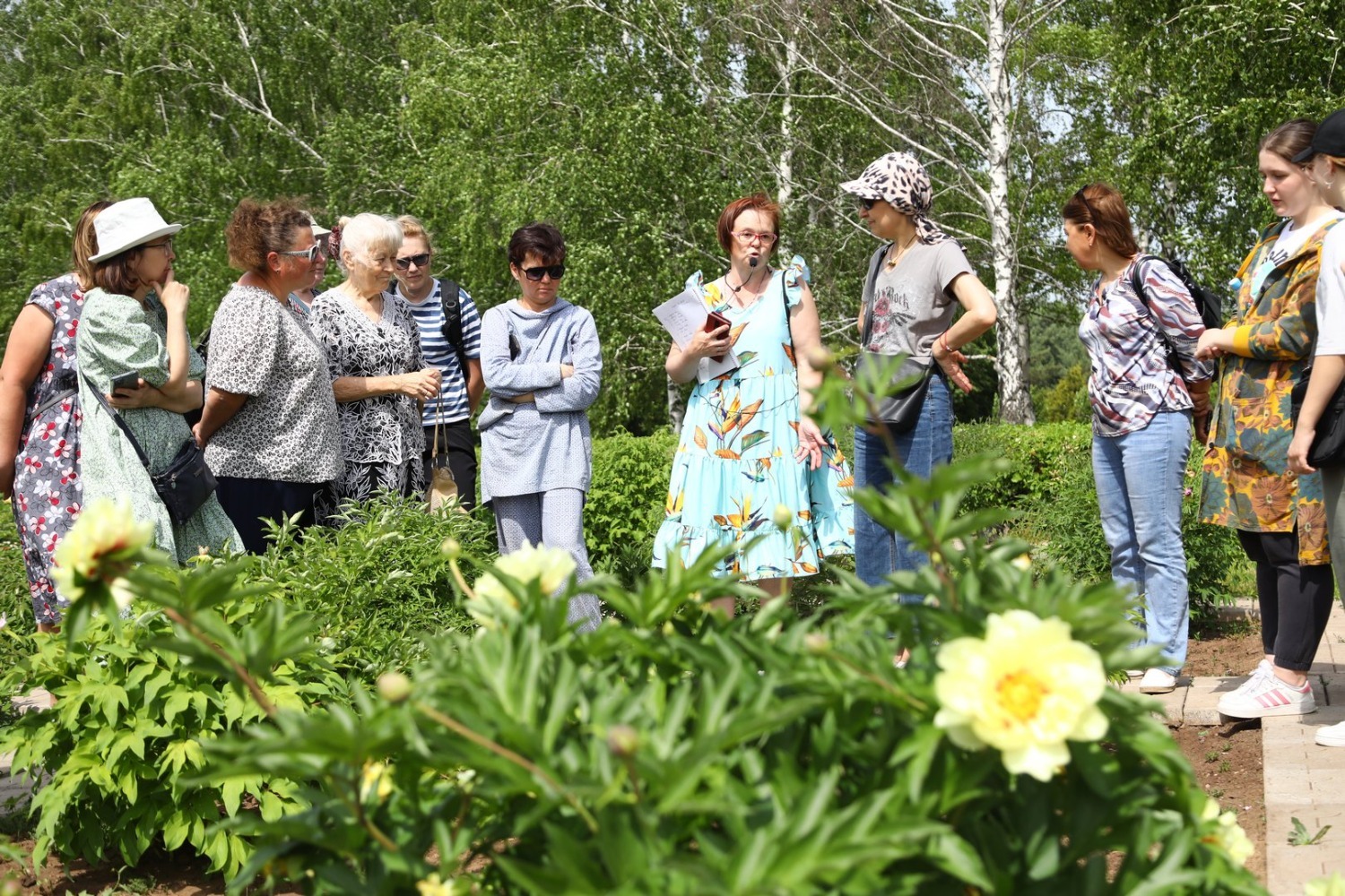 Антонина Реут проводит экскурсию по участку ито-гибридов